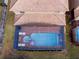 Aerial view of screened pool with flamingo and volleyball net, with patio furniture and red brick tiling at 8924 Bengal Ct, Kissimmee, FL 34747