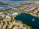 Aerial view showcasing community amenities, lake with fountain, lush landscaping, and residential area at 8924 Bengal Ct, Kissimmee, FL 34747