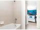 Bright bathroom featuring a shower-tub combo and access to bedroom with ocean themed mural at 8924 Bengal Ct, Kissimmee, FL 34747