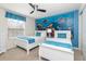 Colorful bedroom with twin beds, Finding Nemo decor, a ceiling fan, and a window with stylish valance at 8924 Bengal Ct, Kissimmee, FL 34747