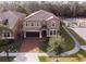 Aerial view of a two-story house with a brick driveway, tile roof, and manicured landscaping at 8924 Bengal Ct, Kissimmee, FL 34747