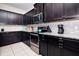 Modern kitchen featuring granite countertops, stainless steel appliances, and dark cabinetry at 8924 Bengal Ct, Kissimmee, FL 34747