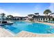 Large community pool surrounded by palm trees and lounge chairs at 8924 Bengal Ct, Kissimmee, FL 34747