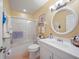 This is a bathroom with a white shower and white sink with a round mirror at 903 Oak Leaf Ct, Altamonte Springs, FL 32714