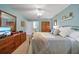 Inviting bedroom with blue walls, plush bedding, hardwood cabinets and a glimpse into the en-suite bathroom at 903 Oak Leaf Ct, Altamonte Springs, FL 32714