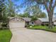 A single-story home featuring a two-car garage, well-manicured lawn, and beautiful landscaping at 903 Oak Leaf Ct, Altamonte Springs, FL 32714