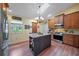 The kitchen features a dark wood island with granite countertops, stainless steel appliances and a charming chandelier at 903 Oak Leaf Ct, Altamonte Springs, FL 32714