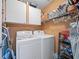 Laundry room with side by side white washer and dryer, overhead cabinets and storage shelves at 903 Oak Leaf Ct, Altamonte Springs, FL 32714