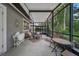 This screened patio features chairs, a table, and a view of trees at 903 Oak Leaf Ct, Altamonte Springs, FL 32714