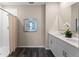 Well-lit bathroom featuring a double vanity, framed mirrors, a walk-in shower, and wood-look flooring at 984 Commons Way, Port Orange, FL 32129