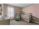 Cozy Bedroom with a crib, glider chair, soft pink curtains, and heart-themed wall decor at 984 Commons Way, Port Orange, FL 32129