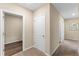 Hallway with neutral walls, carpet, and white trim, with doors leading to various rooms in the home at 984 Commons Way, Port Orange, FL 32129