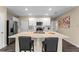 Spacious kitchen features modern stainless-steel appliances, white cabinetry, and a center island with bar seating at 984 Commons Way, Port Orange, FL 32129