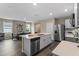 Modern kitchen with stainless steel appliances, an island with a sink, and an adjacent dining area at 984 Commons Way, Port Orange, FL 32129