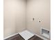 Compact laundry area with utility connections, including a drain pan on dark wood-look flooring at 984 Commons Way, Port Orange, FL 32129