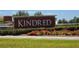 Community entrance sign for Kindred with beautiful flowers, shrubs and green grass at 1596 Park Side Ave, Kissimmee, FL 34744