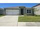 Charming single-story home featuring a two-car garage and well-maintained front lawn at 1596 Park Side Ave, Kissimmee, FL 34744