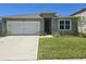 Charming single-story home featuring a two-car garage and well-maintained front lawn at 1596 Park Side Ave, Kissimmee, FL 34744
