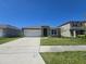 Charming single-story home featuring a two-car garage and well-maintained front lawn at 1596 Park Side Ave, Kissimmee, FL 34744