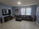 Comfortable living room with tile floors, black leather sofa, and lots of open space at 1596 Park Side Ave, Kissimmee, FL 34744