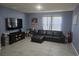 Comfortable living room with tile floors, black leather sofa, and lots of open space at 1596 Park Side Ave, Kissimmee, FL 34744