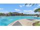 Community pool surrounded by lounge chairs, umbrellas, tables and palm trees at 1596 Park Side Ave, Kissimmee, FL 34744