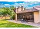 Home's backyard features a screened-in porch and patio surrounded by lush landscaping and blue skies at 103 Golf Club Dr, Longwood, FL 32779