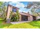 Home's backyard features a screened-in porch and patio surrounded by lush landscaping and blue skies at 103 Golf Club Dr, Longwood, FL 32779