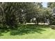 Lush green lawn with mature trees creating a serene and shaded landscape at 103 Golf Club Dr, Longwood, FL 32779