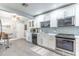 Bright kitchen with white cabinets, modern backsplash, stainless steel appliances, and dining area at 103 Golf Club Dr, Longwood, FL 32779