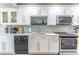 Bright kitchen with white cabinets, modern backsplash, and stainless steel appliances at 103 Golf Club Dr, Longwood, FL 32779