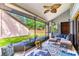 Relaxing screened-in porch features comfortable seating, a ceiling fan, and serene backyard views at 103 Golf Club Dr, Longwood, FL 32779