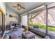 Relaxing screened-in porch features comfortable seating, a ceiling fan, and serene backyard views at 103 Golf Club Dr, Longwood, FL 32779