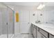 Bright bathroom with a double sink vanity, framed mirror, walk-in shower, and tiled shower walls at 10915 Leafshore Loop, Orlando, FL 32829