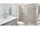 Bright bathroom featuring a white shower, frameless mirror, and gray cabinets at 10915 Leafshore Loop, Orlando, FL 32829