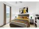 Bedroom featuring a grey upholstered headboard, modern art, side tables, and a window with a view at 10915 Leafshore Loop, Orlando, FL 32829