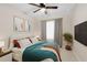 Comfortable bedroom with modern art, neutral carpet, king-size bed, ceiling fan, and a TV at 10915 Leafshore Loop, Orlando, FL 32829
