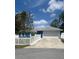 Charming single-story home with a two-car garage, white picket fence, blue exterior, and well-maintained lawn at 11 Pecan Run Ct, Ocala, FL 34472