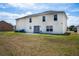 A spacious backyard featuring a two-story home with a patio and ample green space, perfect for outdoor activities at 114 Shaddock Dr, Auburndale, FL 33823