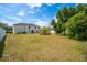 The home has a large backyard offering privacy, with a vibrant palm tree adding tropical charm to the outdoor space at 114 Shaddock Dr, Auburndale, FL 33823