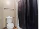 Bathroom with toilet, and a shower with a dark shower curtain at 114 Shaddock Dr, Auburndale, FL 33823
