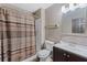 Bathroom with patterned curtain, toilet and sink with mosaic tile backsplash at 114 Shaddock Dr, Auburndale, FL 33823