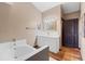 Bright bathroom featuring a soaking tub and vanity with a decorative gold mirror at 114 Shaddock Dr, Auburndale, FL 33823