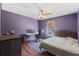 Purple bedroom with a desk, chair and a bed with a ceiling fan at 114 Shaddock Dr, Auburndale, FL 33823