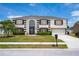 Charming two-story home featuring a well-manicured lawn and a classic architectural style at 114 Shaddock Dr, Auburndale, FL 33823