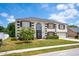 Attractive two-story home with lush landscaping, a well-maintained lawn, and a charming facade at 114 Shaddock Dr, Auburndale, FL 33823