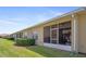 Home's exterior features a screened lanai, manicured lawn and tidy landscaping at 1161 Trappers Trail Loop, Davenport, FL 33896