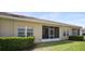 Home's exterior features a screened lanai, manicured lawn and tidy landscaping at 1161 Trappers Trail Loop, Davenport, FL 33896
