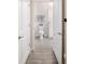 Neutral toned bathroom featuring gray-wood flooring, white cabinetry, and shower with floral curtain at 1161 Trappers Trail Loop, Davenport, FL 33896