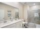 Bright bathroom features a double sink vanity with white cabinets and a glass enclosed shower at 1161 Trappers Trail Loop, Davenport, FL 33896